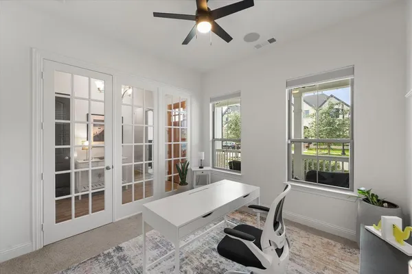 a view of a workspace with furniture and a window