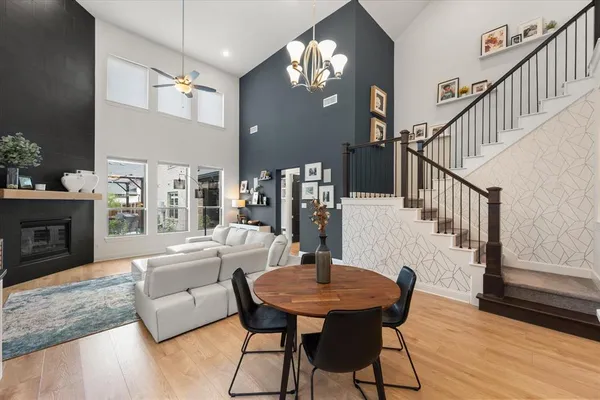 a living room with furniture a chandelier a fireplace and a flat screen tv
