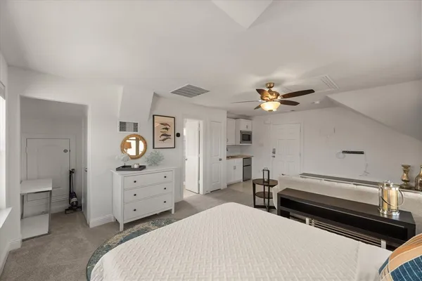a spacious bedroom with a bed and a chandelier
