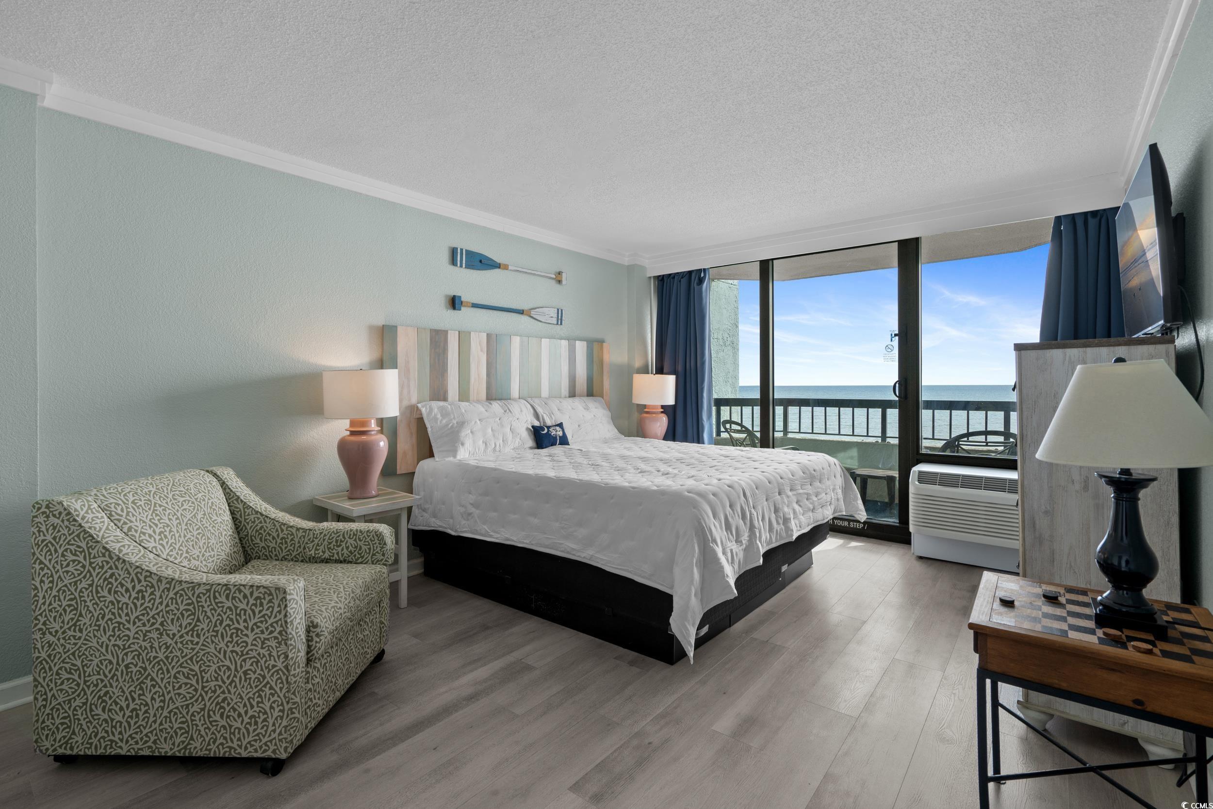 2401 South Ocean Boulevard, Unit 659 Myrtle Beach, SC 29577 - Photo 19 of 38 Bedroom with crown molding, a textured ceiling, wood finished floors, access to outside, and floor to ceiling windows