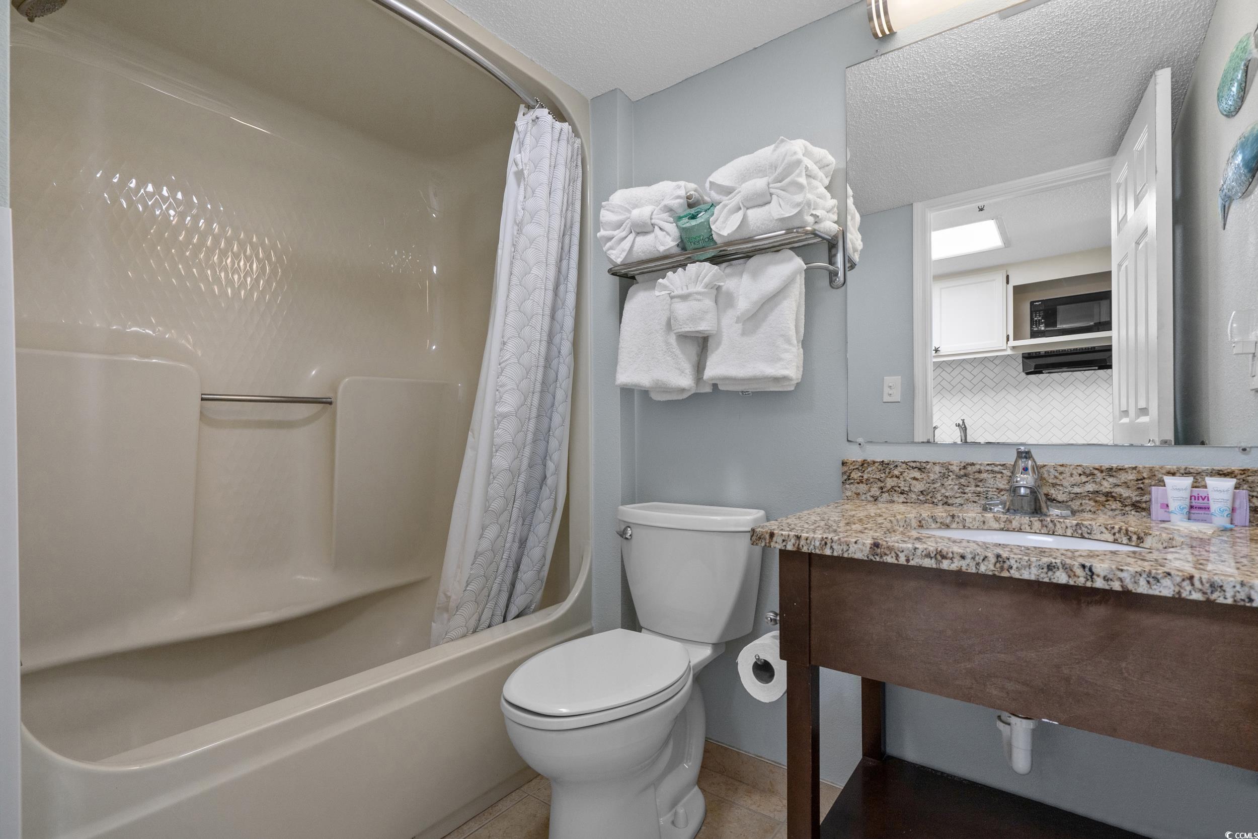 2401 South Ocean Boulevard, Unit 659 Myrtle Beach, SC 29577 - Photo 24 of 38 Full bath with shower / bath combo, a textured ceiling, vanity, and light tile patterned flooring