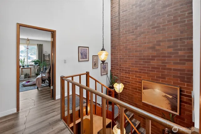 a view of a hallway with wooden floor and staircase