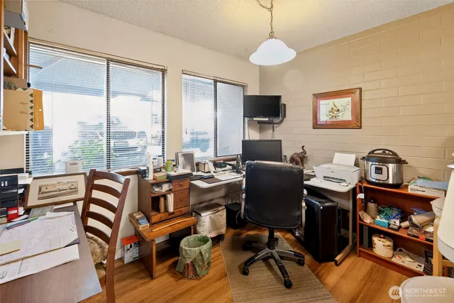 a view of a workspace with furniture and a window