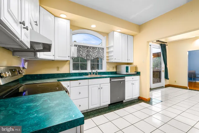 a kitchen with a sink a refrigerator and cabinets