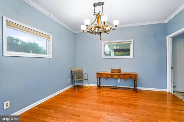 a view of empty room with window and chandelier