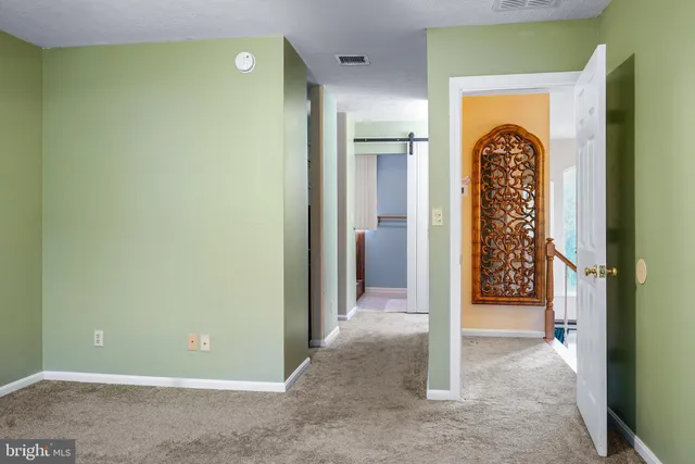 a bedroom with a bed and a dresser next to a window