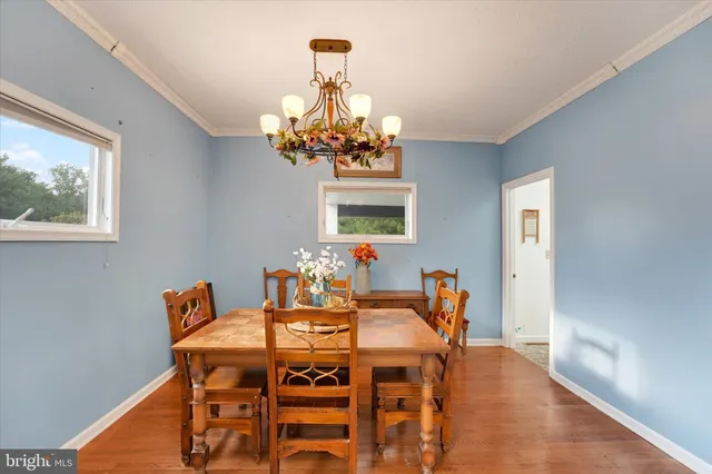 a dining room with furniture a chandelier and window