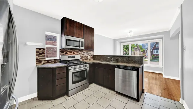 a kitchen with stainless steel appliances granite countertop a stove a microwave and a sink