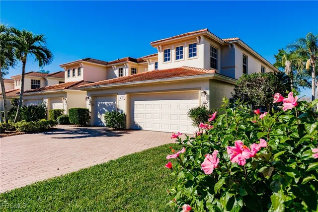 a front view of a house with a yard and flowers
