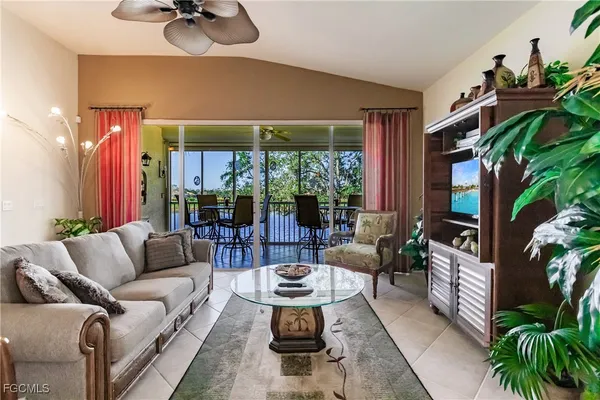 a living room with furniture potted plant and a large window
