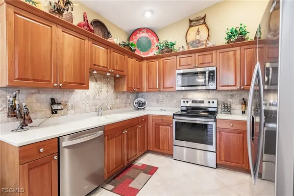 a kitchen with kitchen island granite countertop a sink cabinets stainless steel appliances and a counter top