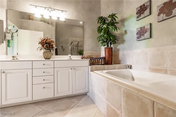 a bathroom with a sink a potted plant and a mirror