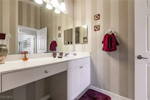 a bathroom with a sink vanity and mirror
