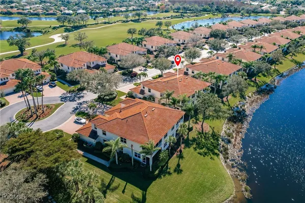 an aerial view of residential houses with outdoor space and lake view
