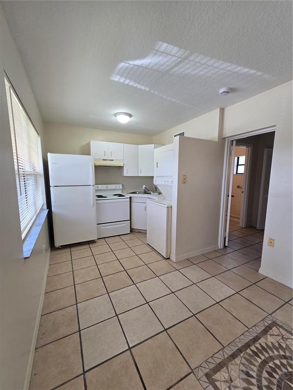 2150 Barbara Drive, Unit 2 St. Cloud, FL 34771 - Photo 6 of 9 a kitchen with a refrigerator and white cabinets