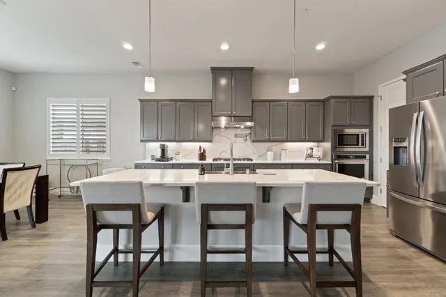 a kitchen with refrigerator a center island and chairs