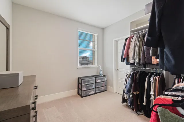 a view of walk in closet with clothes and shoes