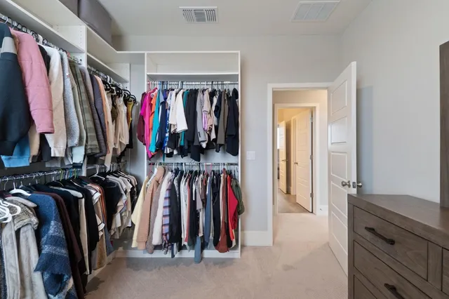 a view of walk in closet with clothes