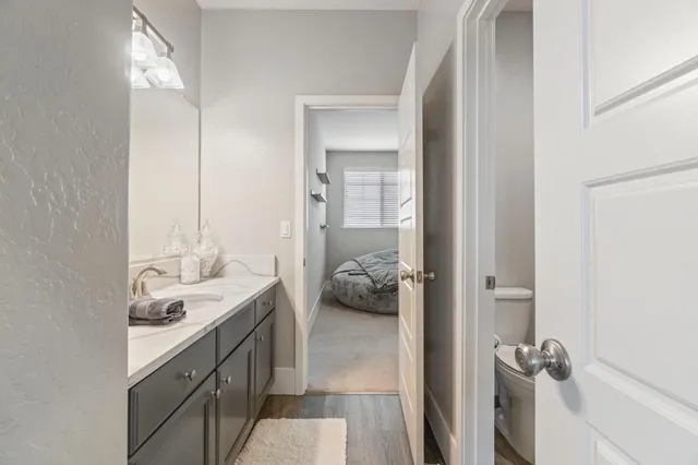 a en suite bathroom with a granite countertop sink and a mirror