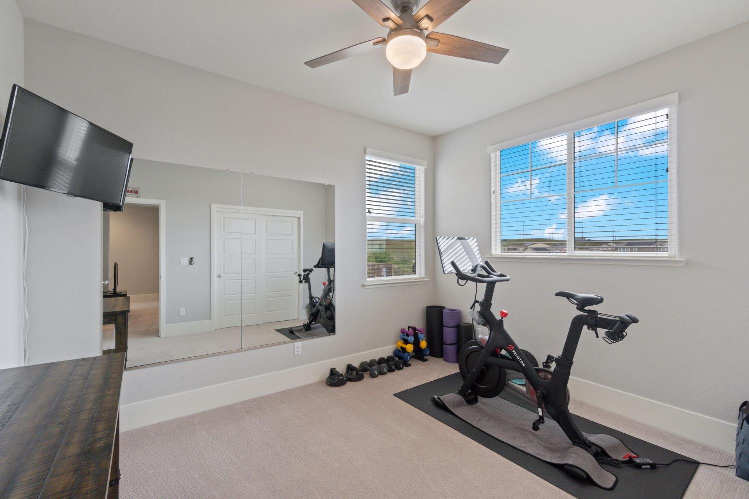 4491 Vineyard Drive Madera, CA 93636 - Photo 31 of 47 a room with gym equipment and windows