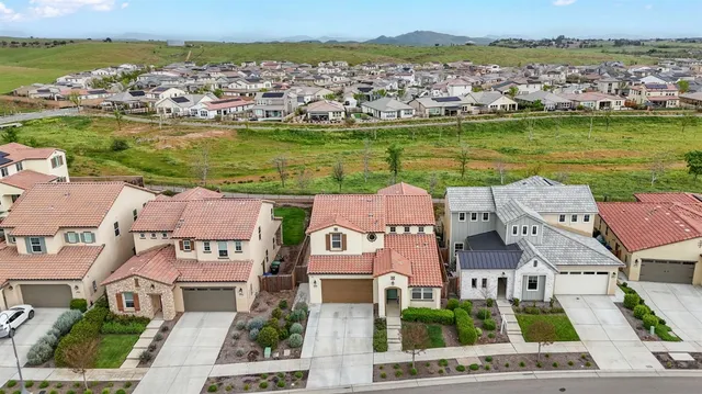 an aerial view of residential houses with outdoor space and ocean view