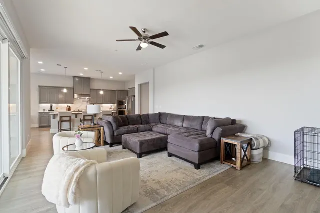 a living room with furniture and a view of kitchen