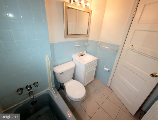 a white toilet sitting next to a bathroom sink and vanity