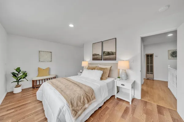 a bedroom with bed and a potted plant