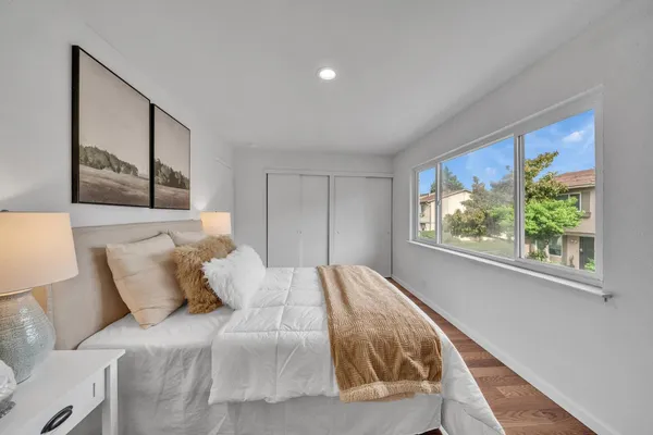 a bed sitting in a bedroom next to a window