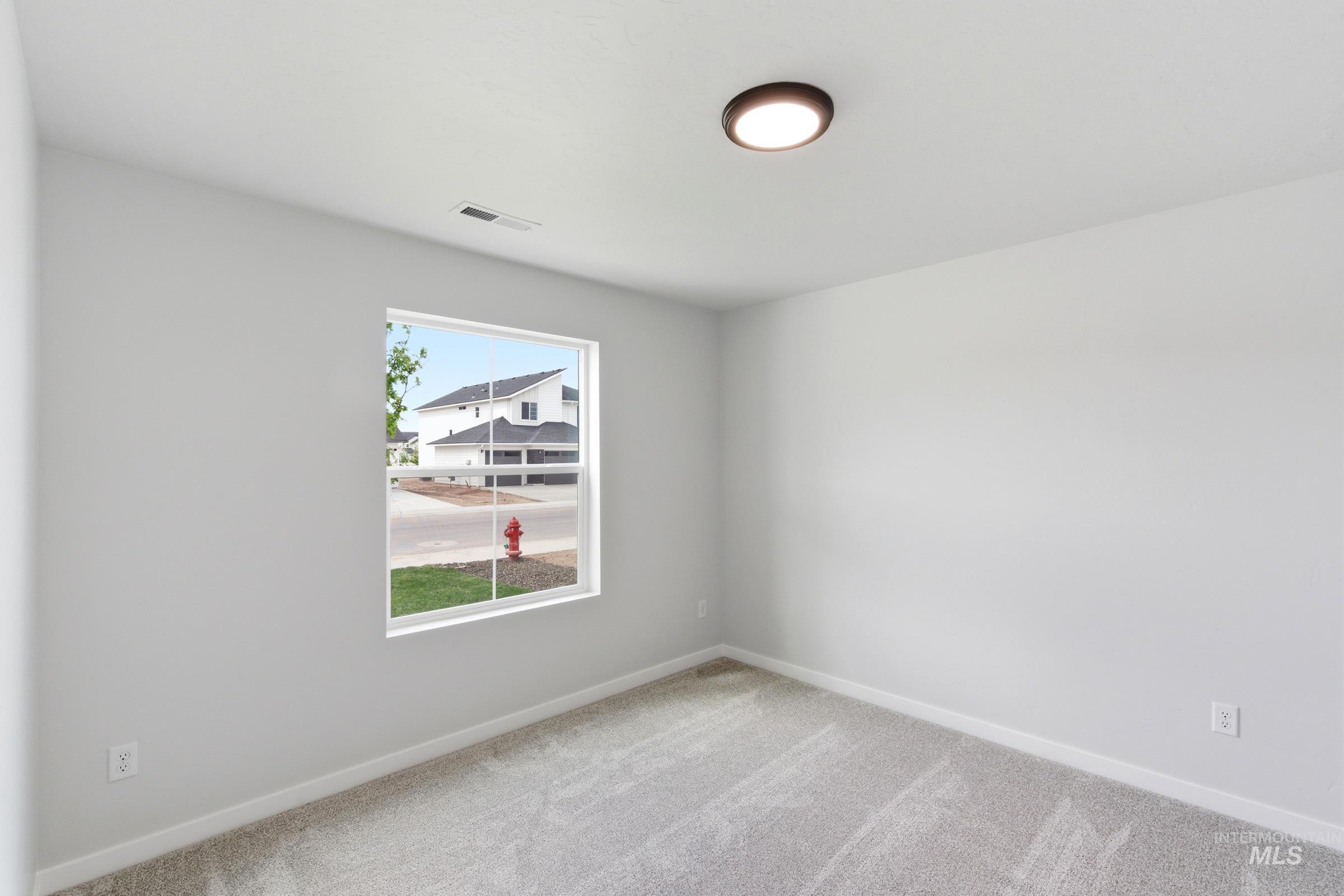 12829 Decatur Street Nampa, ID 83651 - Photo 12 of 33 Carpeted room featuring a single window with white trim, light gray walls, white baseboards, and a flush-mount ceiling light