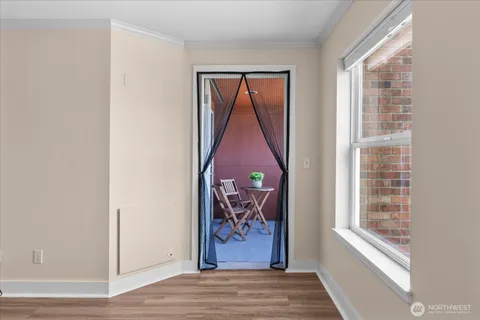 a view of a hallway with wooden floor and a window