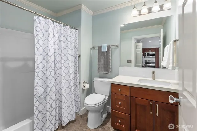 a bathroom with a granite countertop sink toilet a mirror a vanity and shower