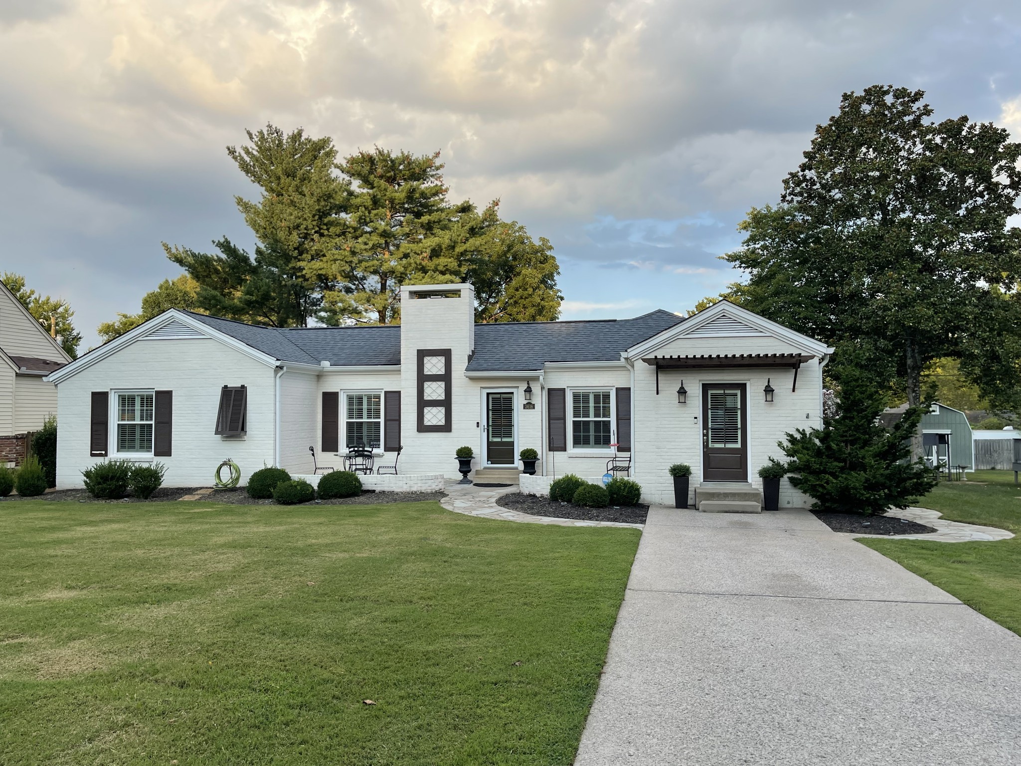 Undisclosed Address Nashville, TN 37204 - Photo 2 of 24 a front view of a house with a garden and trees