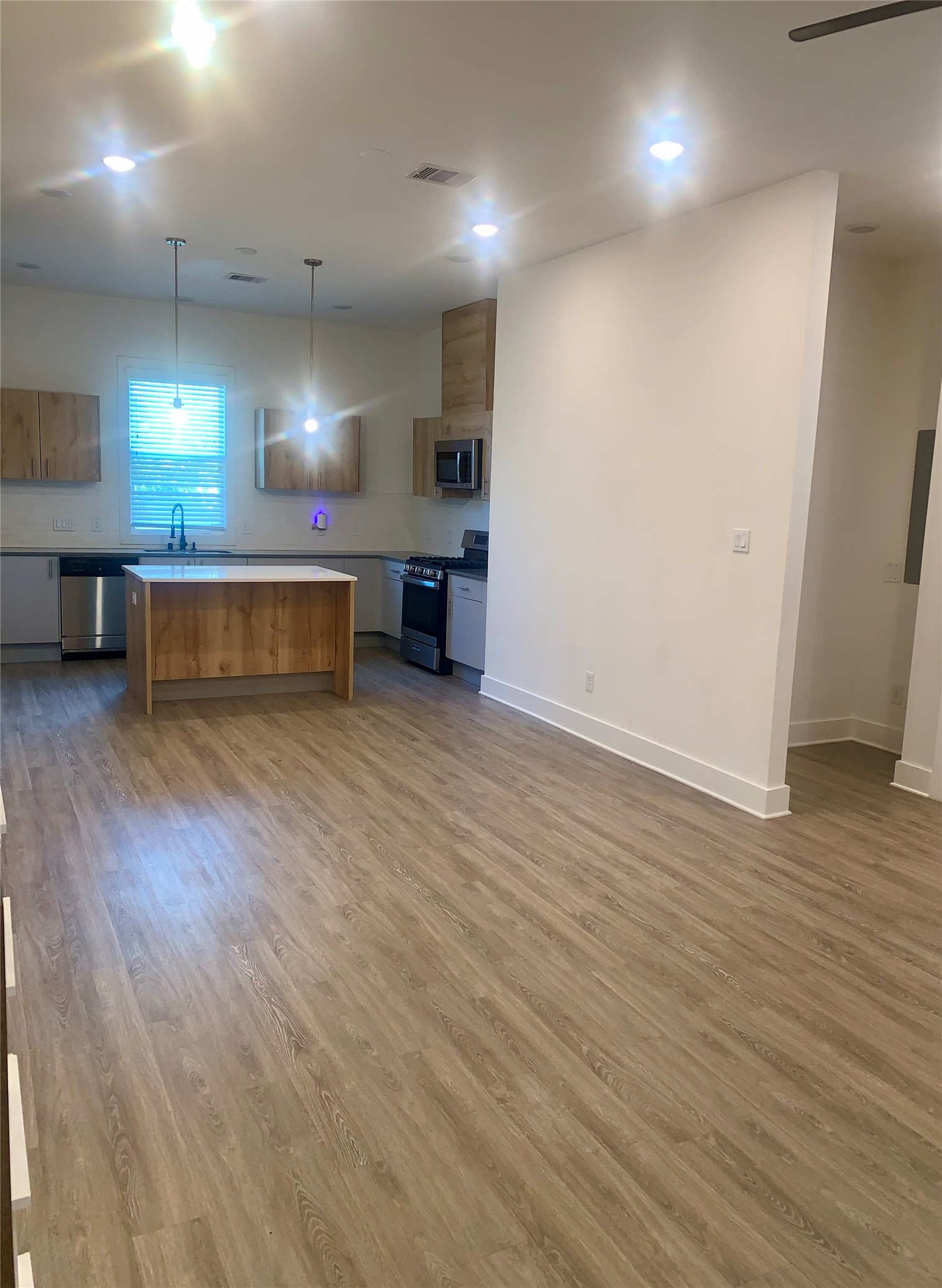 10209 Las Nubes Avenue Houston, TX 77075 - Photo 7 of 29 an empty room with wooden floor cabinet and windows