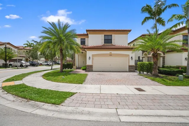 a front view of a house with a yard and garage