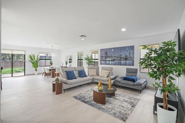 a living room with furniture potted plant and a large window