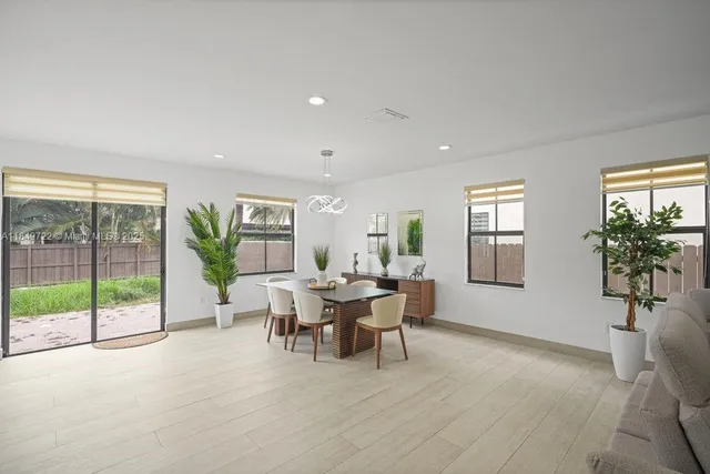 a view of a dining room and livingroom with furniture wooden floor a chandelier