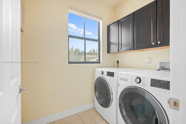 a bedroom with a bed a couch and potted plant on the dresser
