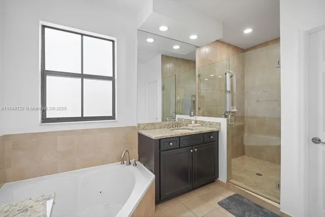 a bathroom with a granite countertop bathtub sink double and mirror