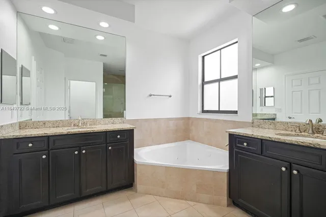 a spacious bathroom with a granite countertop sink and mirror