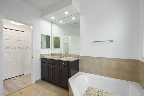 a spacious bathroom with a granite countertop sink and mirror