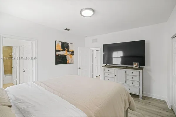 a bedroom with a bed and a flat screen tv