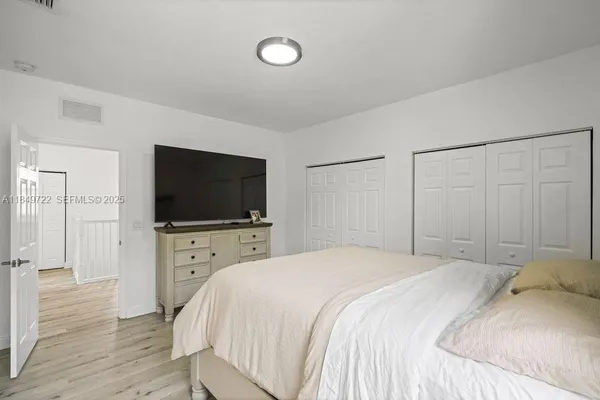a bedroom with a bed and a flat screen tv