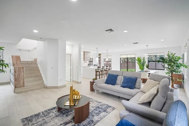 a living room with furniture potted plant and a large window