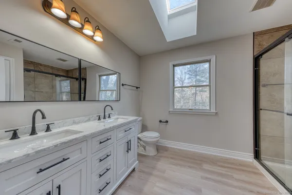 a bathroom with a double vanity sink a toilet and a mirror