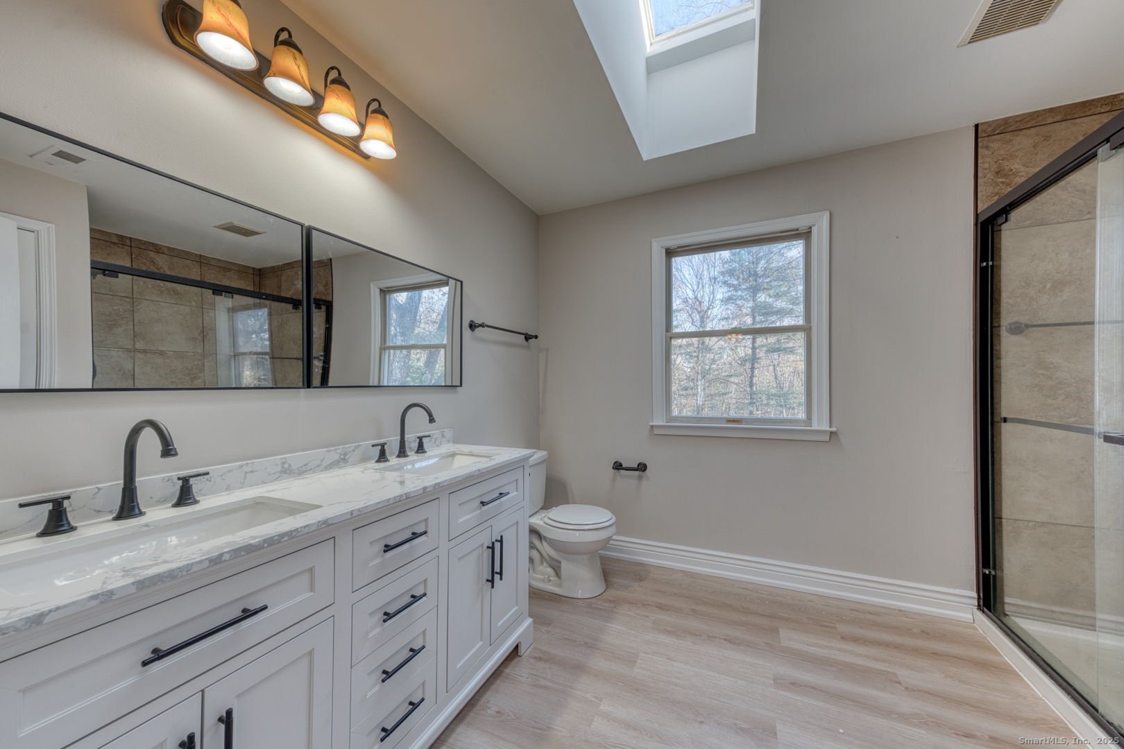 a bathroom with a double vanity sink a toilet and a mirror