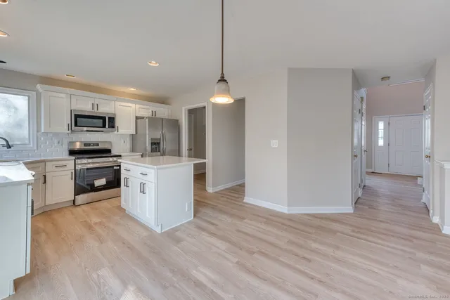 a kitchen with a sink cabinets and wooden floor