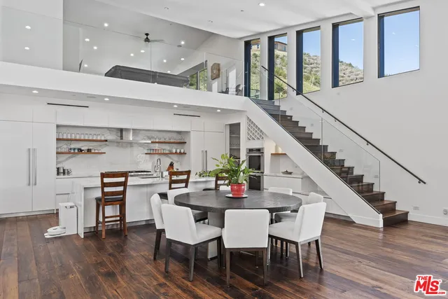 a living room with furniture kitchen view and a flat screen tv