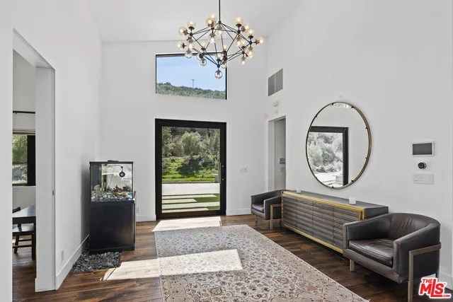 a kitchen with stainless steel appliances a dining table chairs and wooden floor