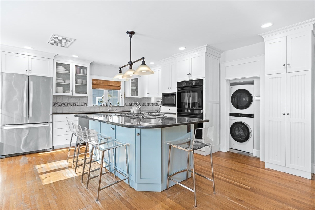 23 Jefferson Road Winchester, MA 01890 - Photo 13 of 41 a kitchen with stainless steel appliances granite countertop a refrigerator a stove and a wooden floors